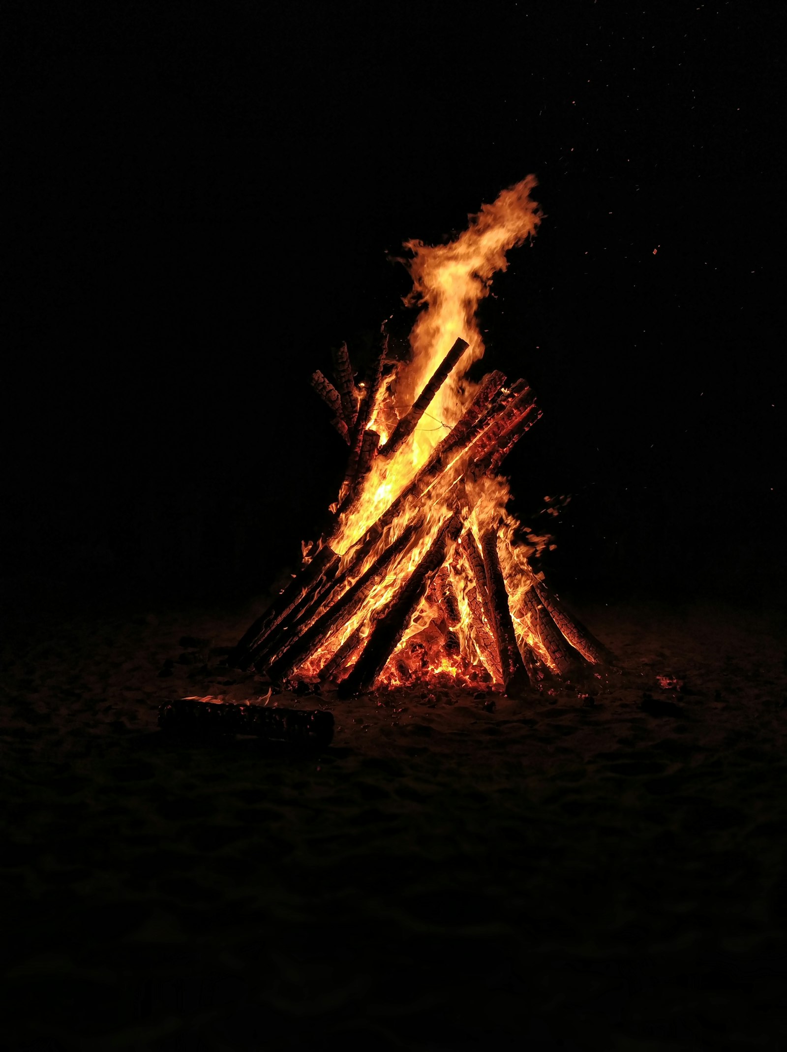 A bonfire on the sand at night