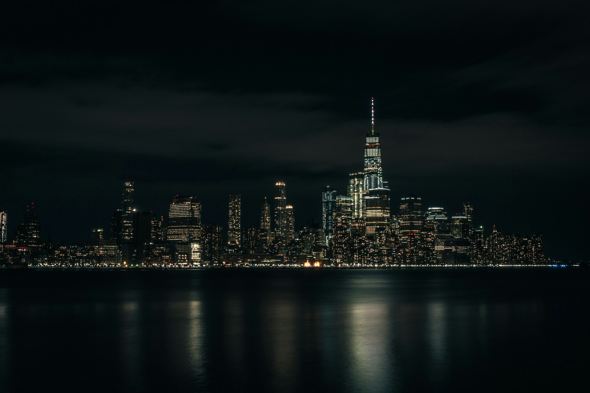 A city skyline at night across the water